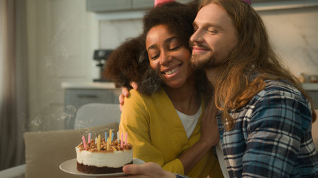 Happy couple multiracial multiethnic Caucasian man guy male boyfriend husband hold cake celebrate...
