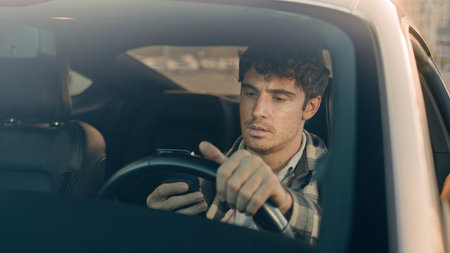 Disappointed stressed sad man Caucasian auto driver businessman inside automobile car waiting in traffic jam using mobile phone read bad news upset displeased loss gps navigation road driving in cityの写真素材