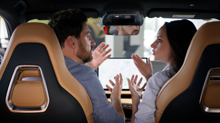 Angry Caucasian couple arguing inside car conflict talking breakup divorce woman girl female girlfriend quarrel with man guy male boyfriend travel navigation problem stress automobile auto argumentの写真素材