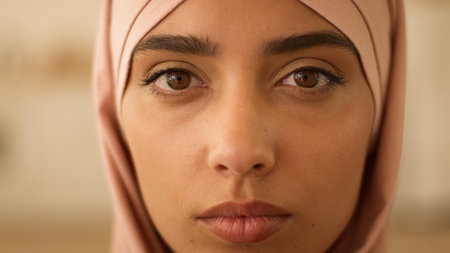 Close up portrait female face serious calm pensive Islamic woman Muslim girl ethnic Islam Arabian lady in hijab religion think looking at camera thinking indoors skin healthy discrimination human raceの写真素材