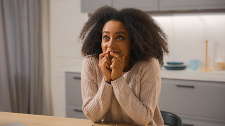 Dreaming ethnic woman African American girl dream wish imagine daydream female at home kitchen happy...