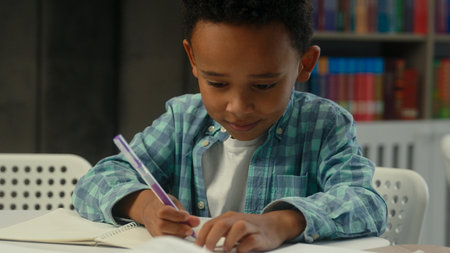 Cute little boy kid child African American son schoolboy elementary primary education studying in...