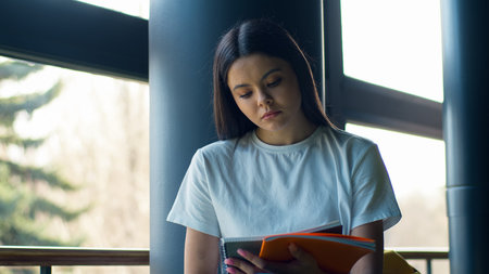 Pensive serious concentrated thoughtful thinking woman girl female student outside outdoors reading...