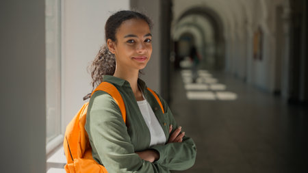 Smiling carefree African American ethnic woman girl student lady pupil female studying learning study learn education in high school university college academy corridor hall looking at camera smileの写真素材