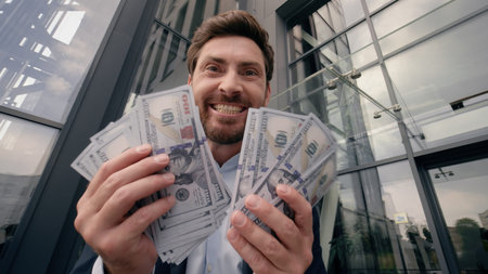 Moving shot happy rich wealthy Caucasian businessman in city looking in camera holding cash money dollars prize financial winning excited yelling celebrate finance bet success business man male guyの写真素材