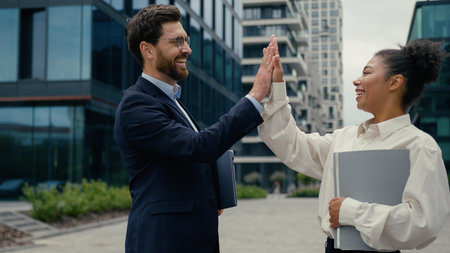 Two multiracial business colleagues friends coworkers meeting greeting high five gesture friendship...