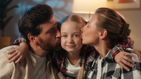 Happy portrait of European family parents kissing daughter in cheeks love kiss parenting concept love bonding affectionate smiling looking at camera satisfied parents with child girl kidの写真素材