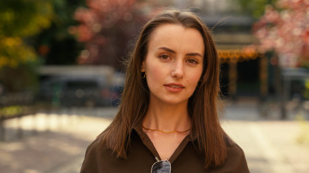 Portrait of serious calm stylish Caucasian woman businesswoman female business girl at street autumn...