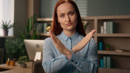 Displeased Caucasian business woman employer office manager female girl sad businesswoman crossing arms stop gesture sign demonstrate no disapprove forbid reject cross hands confident pose workplaceの写真素材
