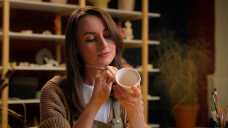Caucasian potter concentrated girl female woman artist painter drawing cup handmade artwork hobby...