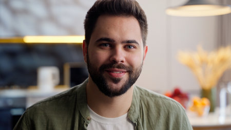 Carefree happy relaxed Caucasian adult bearded man male guy client businessman portrait homeowner model looking at camera friendly smiling wellness weekend relaxation sitting sofa at home living roomの写真素材