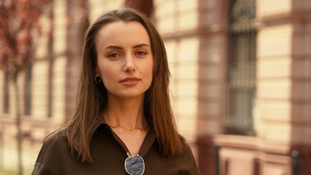 Portrait of serious calm stylish Caucasian woman businesswoman female business girl at street autumn city looking at camera headshot smiling peaceful girlfriend wife outdoors fashion style conceptの写真素材