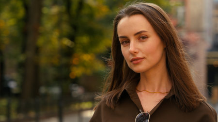 Close up Caucasian stylish happy woman in city calm smiling looking at camera portrait positive beautiful 30s female girl posing in street businesswoman style fashion business lady look smile outdoorsの写真素材