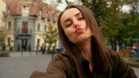 Mobile phone camera view happy smiling Caucasian woman posing smiling make selfie at street female girl in city holding smartphone video call record vlog photo picture online live broadcasting streamの写真素材