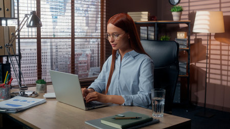 Business female woman businesswoman typing laptop in office smiling girl lady worker in company looking at camera positive working computer pc internet startup job online marketing management workの写真素材