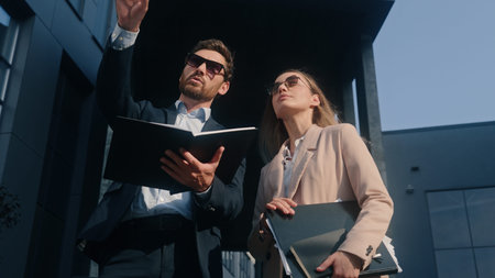 Two stylish teammates businessman talking conversation with businesswoman in sunglasses colleagues...
