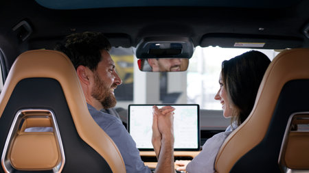 Back view happy family Caucasian couple inside automobile buying auto smiling looking in each other...