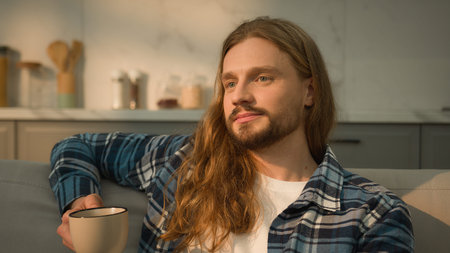 Calm relaxed Caucasian man guy relaxing resting at new rental home apartment real estate kitchen...