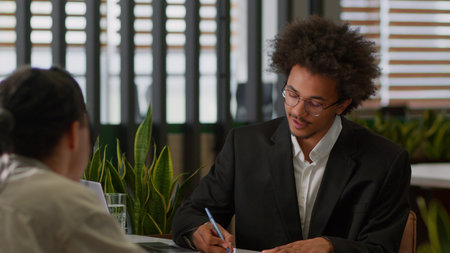 Two business men colleagues signing contract agreement happy deal cooperation partnership African...