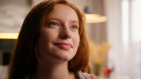 Dreaming inspired portrait girl at home looking away thinking pensive smiling dreamy woman Caucasian young female in living room relaxing daydreaming thoughtful creative calm concentrated contemplateの写真素材