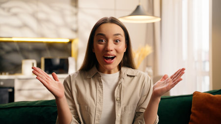 Close up portrait excited happy Caucasian woman European beautiful female smiling rejoice good news surprise in living room looking at camera amazed wonder shocked expression at home girl success gladの写真素材