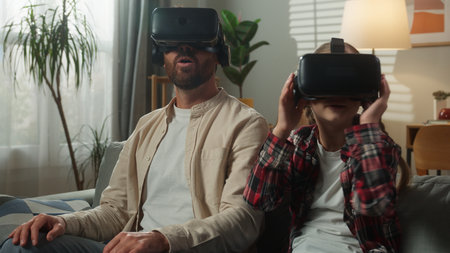 Caucasian family using VR technology father with daughter wearing virtual reality helmets enjoying video game 3d innovation dad with kid child girl playing online gaming cyberspace in living roomの写真素材