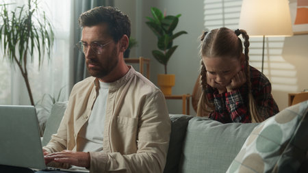 Busy father man male working at home laptop distant from home online ignoring little girl need attention child kid daughter disturb dad sad upset frustrated bad family relationship childcare problemの写真素材