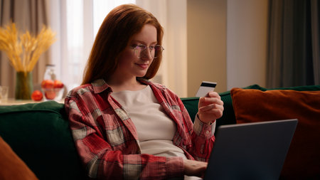 Caucasian happy smiling woman client buyer payment with pc laughing girl female shopping online with computer laptop internet store bank service e-commerce with credit card at home purchase achieveの写真素材