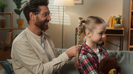 Family father Caucasian man dad caring little lovely adorable child girl braiding healthy hair daughter kid hairstyle hairdo beauty routine at home adopted custody love bonding parenting childcareの写真素材