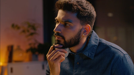 Pensive businessman thoughtful Indian business man writing book in night evening office text...