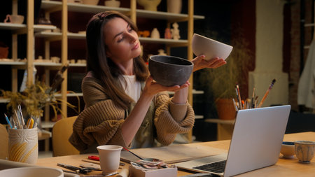 Caucasian woman small business owner saleswoman girl craftswoman decorator artist potter art designer holding two bowls handmade craft store selling crockery ceramics sculpt handcraft pottery workshopの写真素材