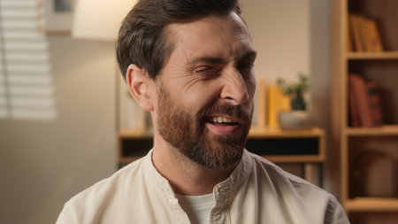 Cheerful Caucasian man joyful happy adult bearded male portrait at home weekend tenant homeowner blogger businessman guy looking at camera flirt wink one eye friendly emotion happiness toothy smileの写真素材