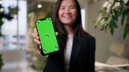 Asian woman smiling Chinese businesswoman Korean Japanese business girl consumer showing mobile phone chroma key green screen mockup copy space smartphone app online shopping cellphone advertisementの写真素材