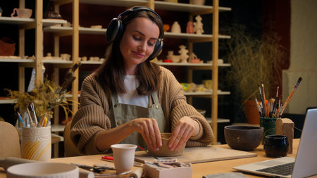 Caucasian relaxed woman girl female potter modeling clay process in workshop pottery hobby smiling...