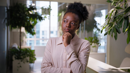 Pensive thoughtful ethnic business woman African American girl sad thinking puzzled businesswoman manager employer in office problem solution think doubt planning brainstorm deep thought idea questionの写真素材