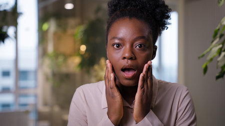 African American business woman shocked businesswoman open mouth excitement amazing news ethnic girl manager employer student shock emotion fright expression excited wow afraid overhelmed in officeの写真素材