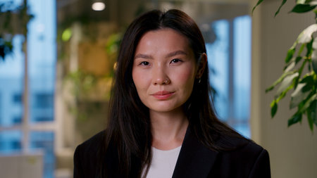 Asian businesswoman portrait in evening office successful business woman beautiful girl manager employer Chinese Korean Japanese female worker entrepreneur looking at camera architect director companyの写真素材