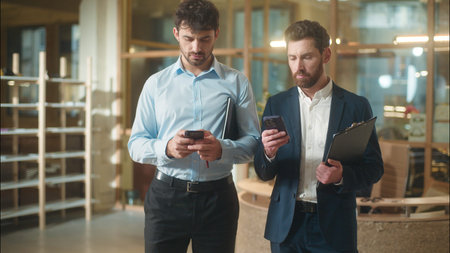 Busy men colleagues businessmen business partners Caucasian guys co-workers managers entrepreneurs usage mobile phones gadgets addict male employees messaging online technology smartphones in officeの写真素材