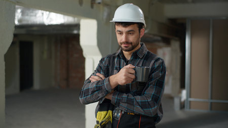 Thoughtful Caucasian man builder civil engineer think planning building construction ponder guy male foreman architect technician repairman puzzled problem solution contemplate drink coffee brainstormの写真素材