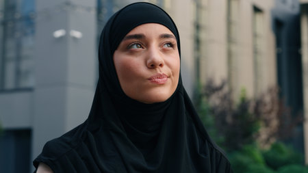Portrait worried hesitate unsure pensive Muslim positive Islamic woman wearing hijab businesswoman business female girl in city outdoor thinking problem solution decide pondering think difficulty ideaの写真素材