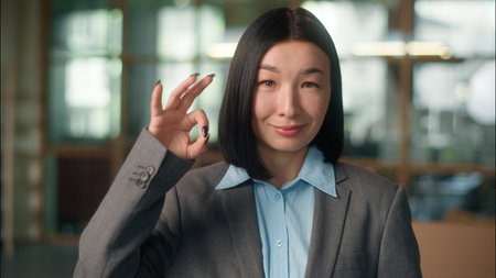 Asian businesswoman Chinese business woman wearing glasses elegant fashion Japanese Korean girl female wear eyeglasses professional employer leader in spectacles vision good okay gesture in officeの写真素材