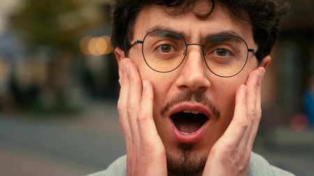 Close up portrait Hispanic man male guy in glasses looking at camera say wow amazed wonder surprised open mouth shock in city amazing news scared afraid shocked businessman reaction business stunnedの写真素材