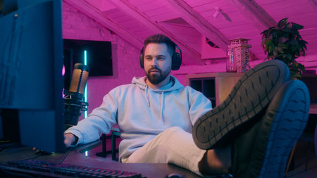 Caucasian guy male gamer man streamer influencer in headphones put legs on table shock wonder problem e-sport gaming talking microphone streaming computer online video game cyber sport addict radioの写真素材