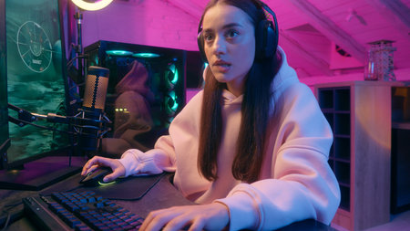 Stressed emotional upset sad Caucasian woman female girl user gamer streamer talking microphone talk to mic worried anxiety playing online video game computer at night neon sport streaming web streamの写真素材