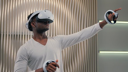 Futurism gaming discovery cyberspace 3d simulation internet video game virtual reality African American man male guy in vr glasses playing in white futuristic room modern technology online metaverseの写真素材
