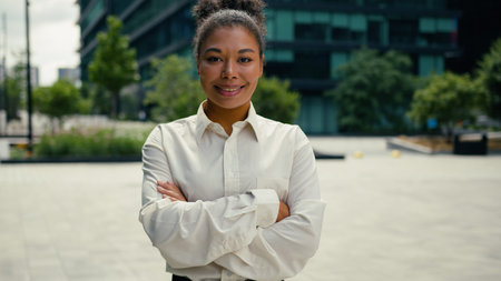 African American businesswoman woman female girl business employer entrepreneur in city posing crossed hands smiling at camera lady manager employer smile positive outside outdoors confident workerの写真素材