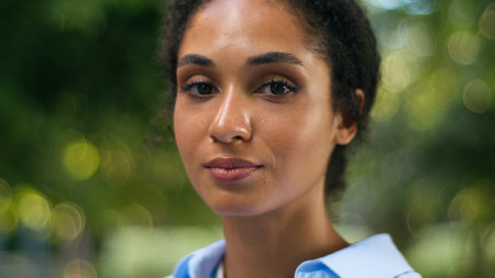 Portrait close up in city calm beautiful pretty African American ethnic face skincare skin facial expression feminism smiling businesswoman woman business girl female lady student looking at cameraの写真素材