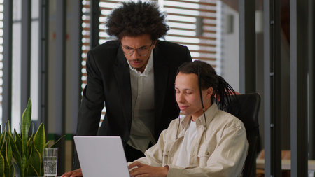 Business intern worker man working with laptop in office African American leader boss mentor coming...