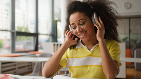 African American woman student girl female in glasses listening music audio song sound in headphones...