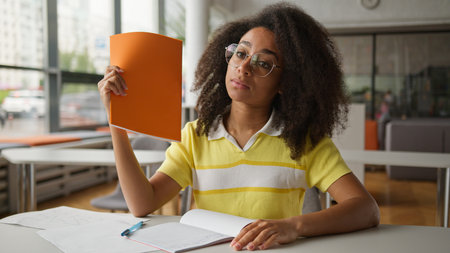 Suffering sweaty African American girl female student business woman businesswoman in office school university library college studying work problem high temperature climate control conditioner brokenの写真素材